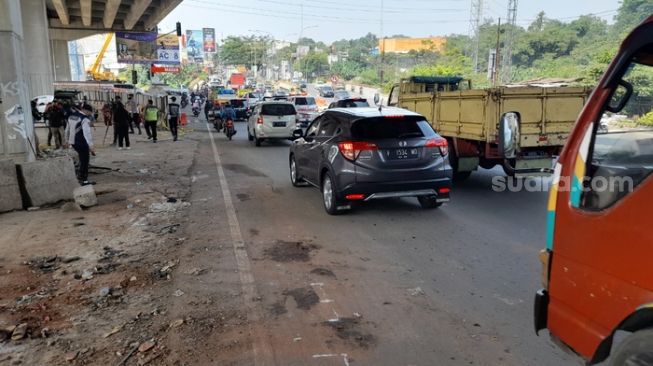 Sejumlah pengendara melintas di lokasi kecelakaan maut di Jalan Transyogi Cibubur-Cileungsi, Kota Bekasi, Selasa (19/7/2022) (Suara.com/Danan Arya)